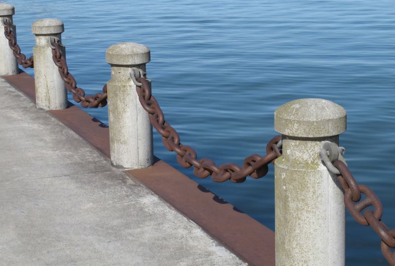Bollards-posts-and-chain-on-a-pier-24682769-min
