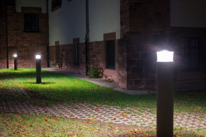 Concrete-bollards-outdoor-lights-in-front-of-an-old-building-illuminating-a-walkway-in-the-garden-at-night-78671407-min