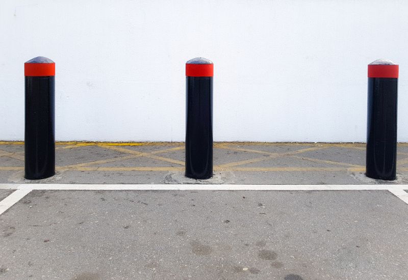 bollard-concrete-security-bollards-vehicle-crash-barriers-in-a-parking-lot-min