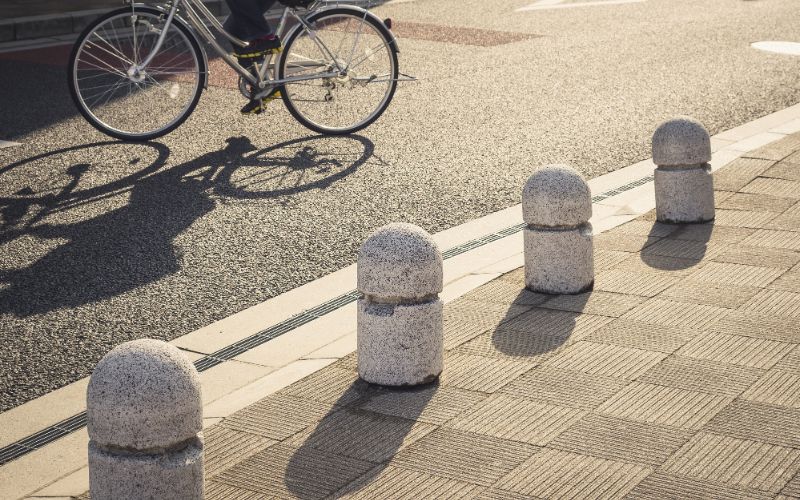 Bollards-bollards-on-walkway-city-people-cycling-on-street-urban-lifestyle--min